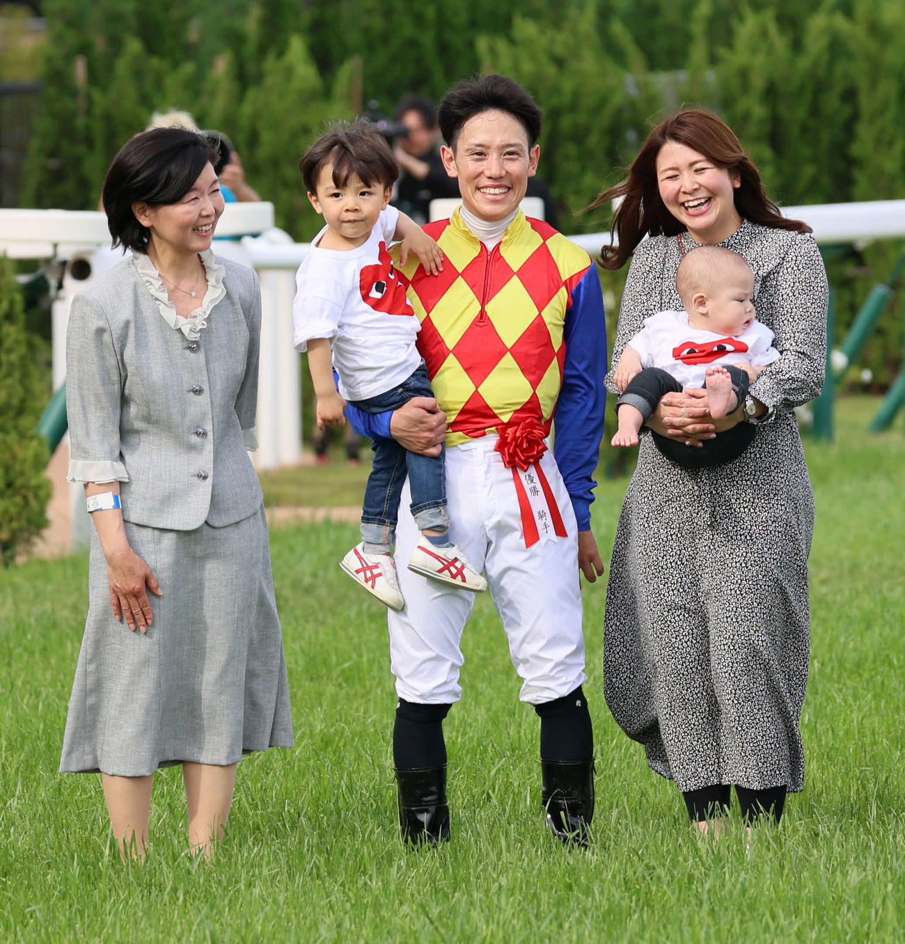 天皇賞・春をテーオーロイヤルで制しG1初制覇の菱田騎手は口取りで家族と写真に納まる（撮影・西尾就之）