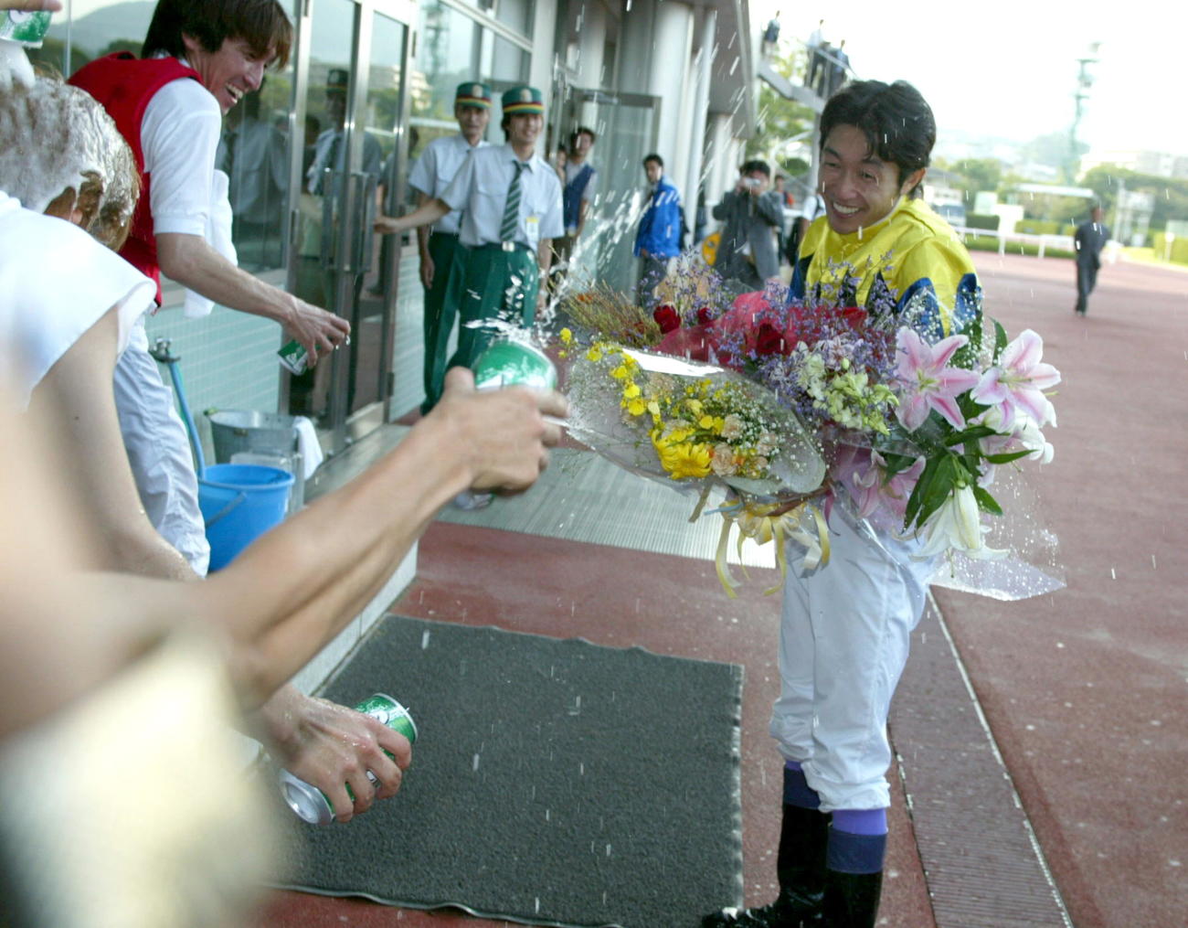 02年9月、JRA通算2000勝を達成し、シャンパンシャワーならぬ缶ジュースで祝福を受ける武豊騎手