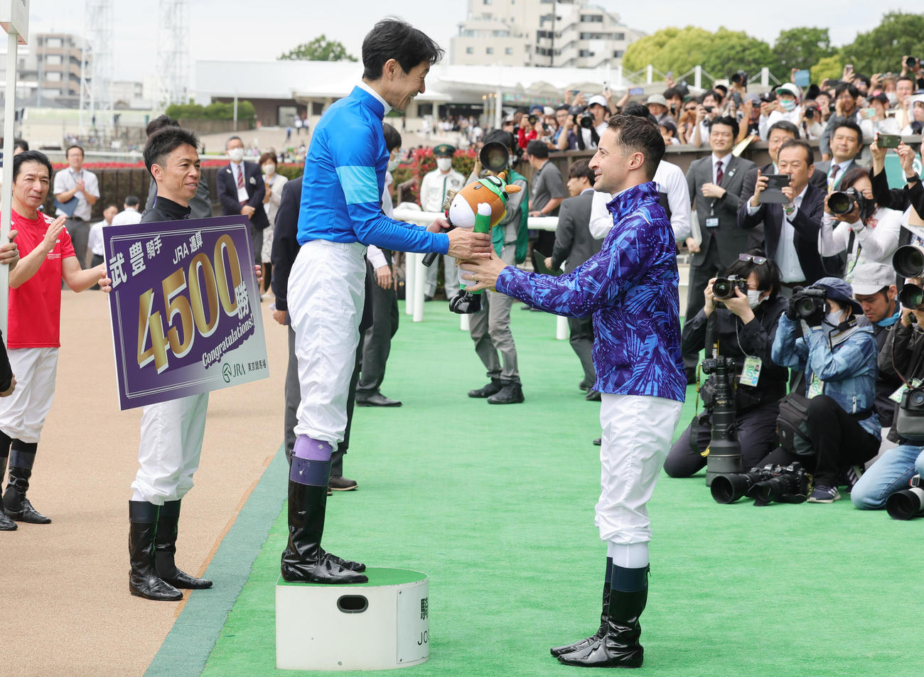 東京2RでJRA通算4500勝を達成し、ルメール騎手（右）から祝福される武豊騎手（撮影・野上伸悟）