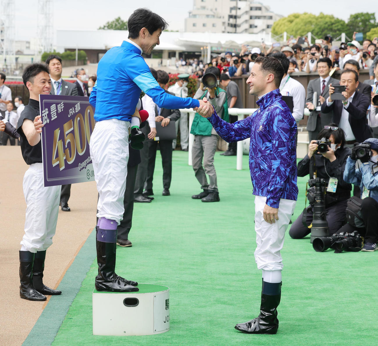 東京2RでJRA通算4500勝を達成し、ルメール騎手（右）から祝福される武豊騎手（撮影・野上伸悟）