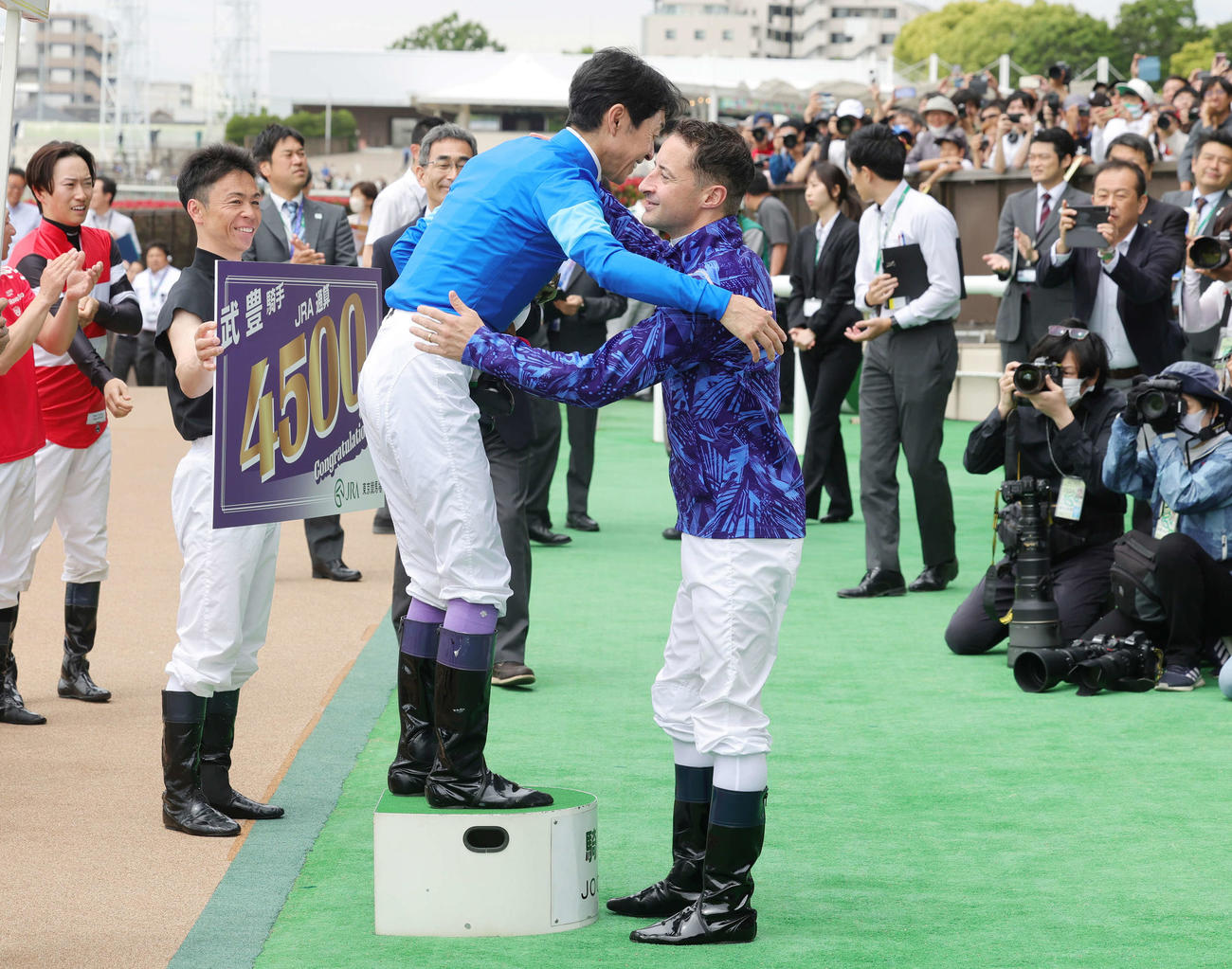 東京2RでJRA通算4500勝を達成し、ルメール騎手（右）から祝福される武豊騎手（撮影・野上伸悟）