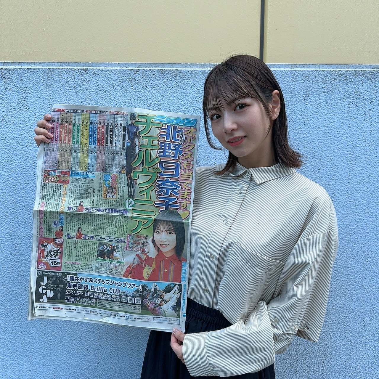 オークスでチェルヴィニアを本命にした日刊スポーツを手にする元乃木坂46北野日奈子（事務所提供）