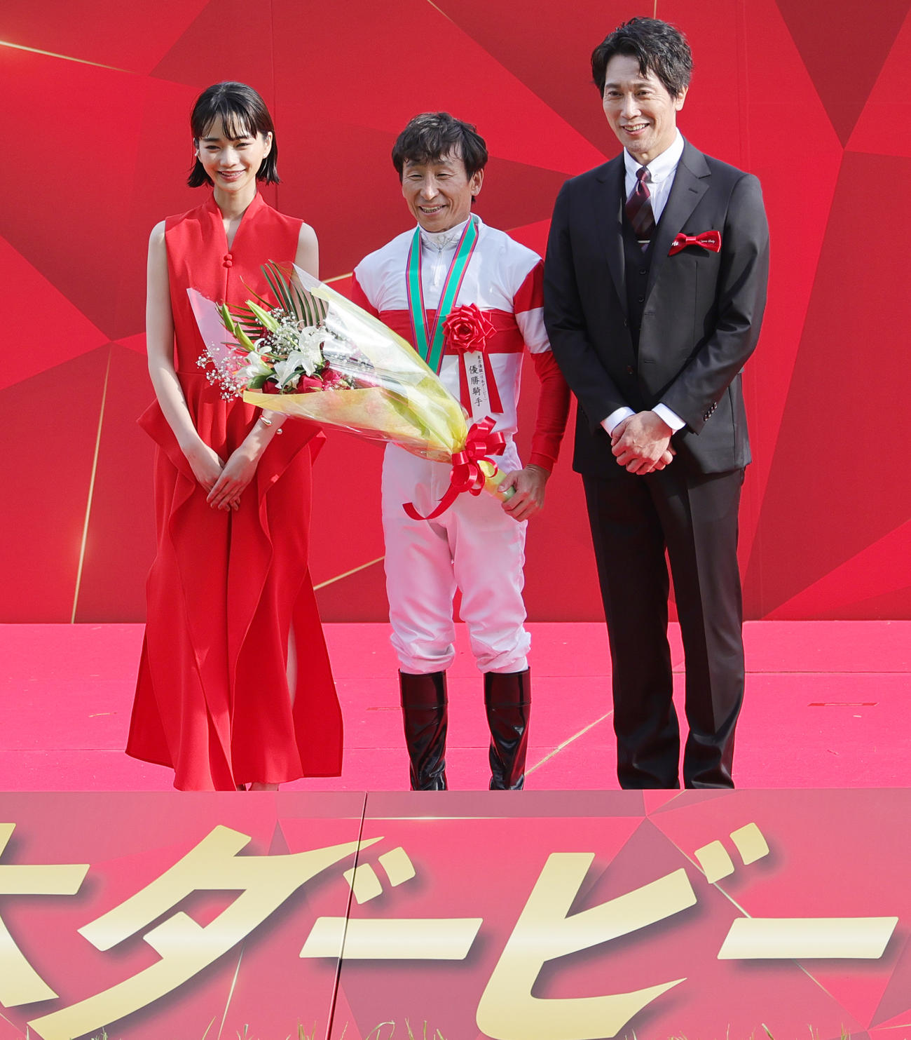 日本ダービーを制し、プレゼンターの見上愛（左）、佐々木蔵之介（右）と記念撮影する横山典弘騎手