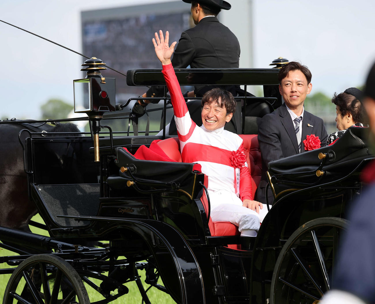 日本ダービーを制し、馬車パレードでファンに手を振る横山典騎手（左）と安田翔師（撮影・鈴木正人）