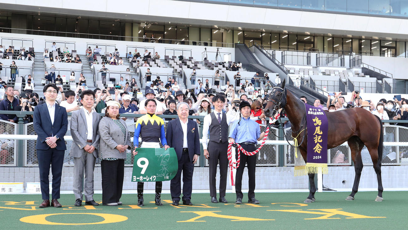 鳴尾記念を勝利したヨーホーレイクと口取りに並ぶ岩田望騎手（中央）（撮影・白石智彦）