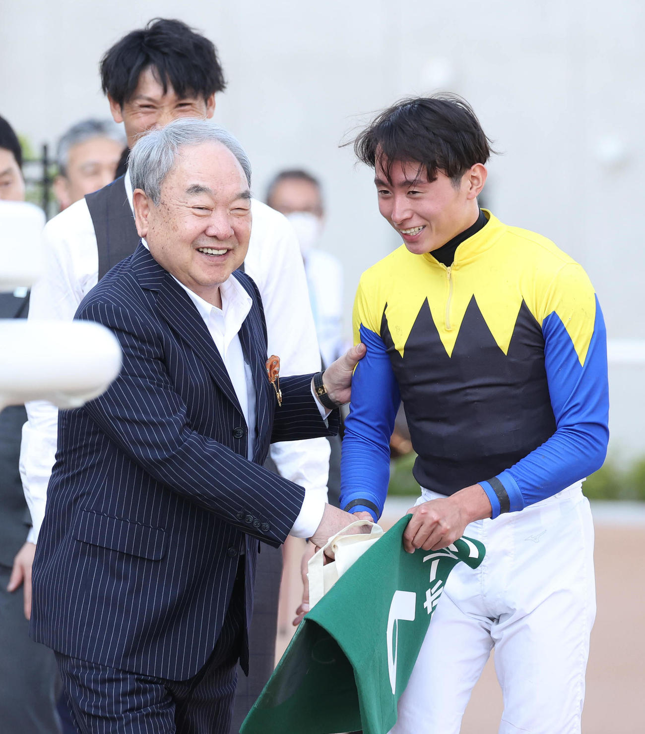 笑顔で握手する金子真人オーナー（左）と岩田望騎手（撮影・白石智彦）
