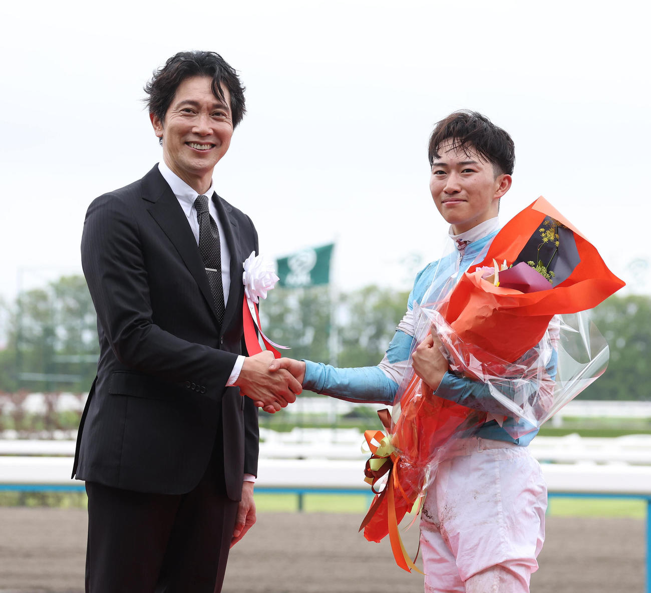 宝塚記念　表彰式で握手するプレゼンターの佐々木蔵之介（左）と菅原明騎手（撮影・白石智彦）