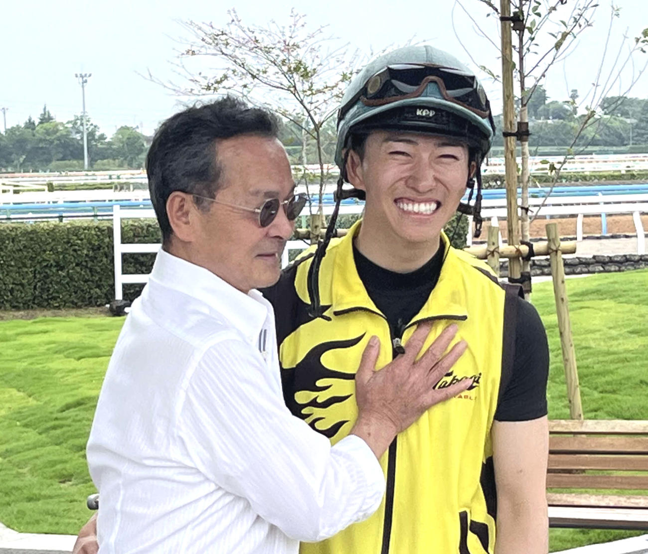 ブローザホーンを管理していた中野元師（左）は宝塚記念を同馬で制覇した菅原明騎手（右）を笑顔で祝福する