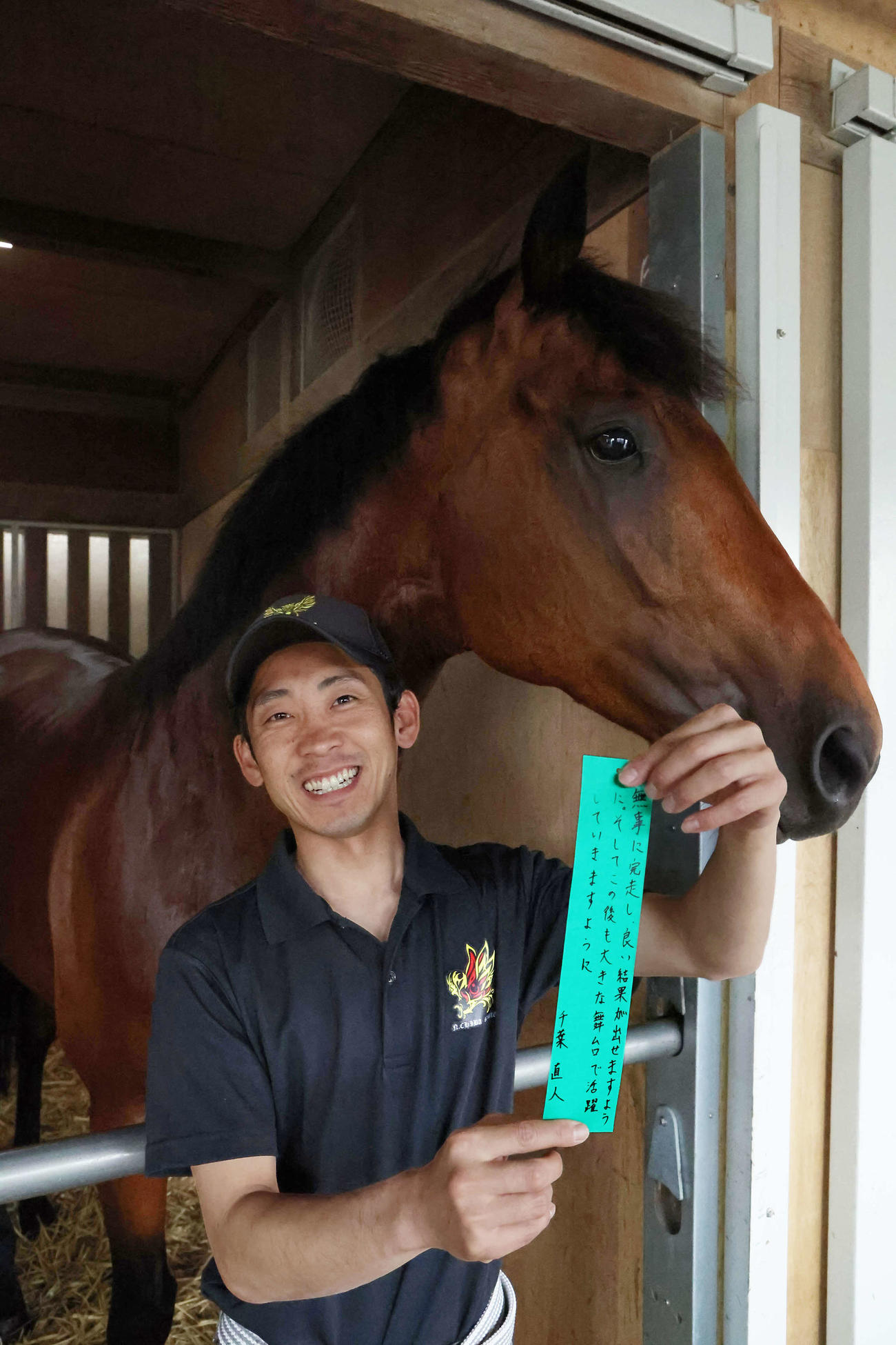 直筆の短冊を手に、笑顔を見せる千葉師（撮影・丹羽敏通）
