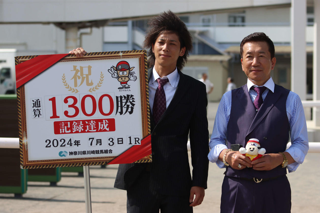 川崎1Rで地方競馬通算1300勝を達成した高月賢一調教師（右）