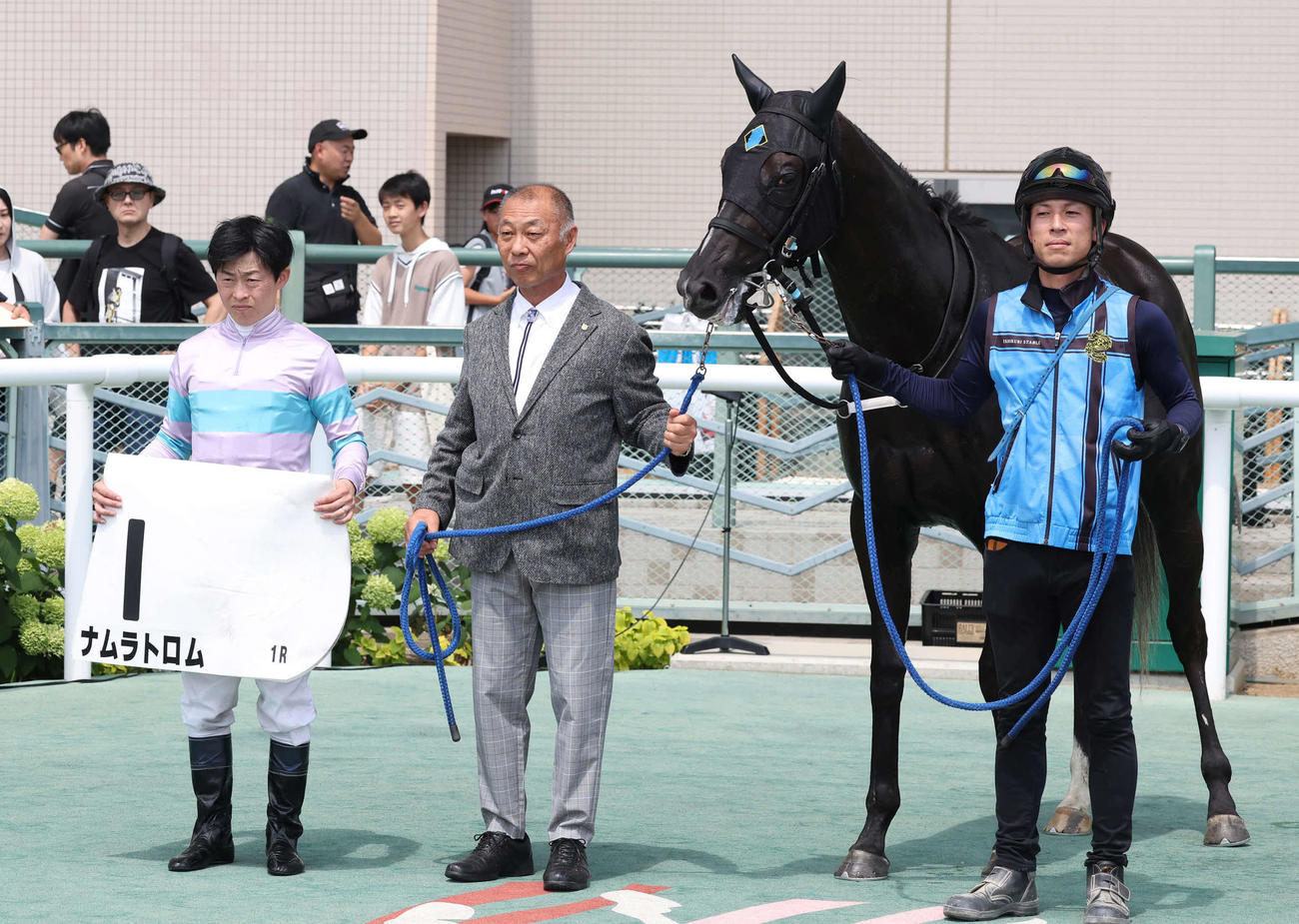 福島1R、2歳未勝利戦を制したナムラトロムの口取りをする丸田騎手と石栗師（撮影・丹羽敏通）