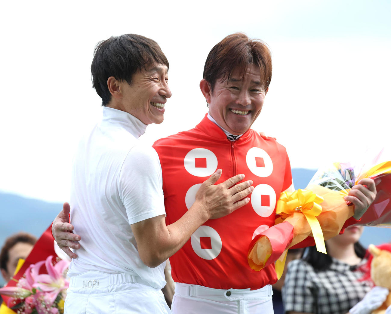 お別れセレモニーで横山典弘騎手（左）と笑顔で抱き合う小牧太騎手（撮影・白石智彦）