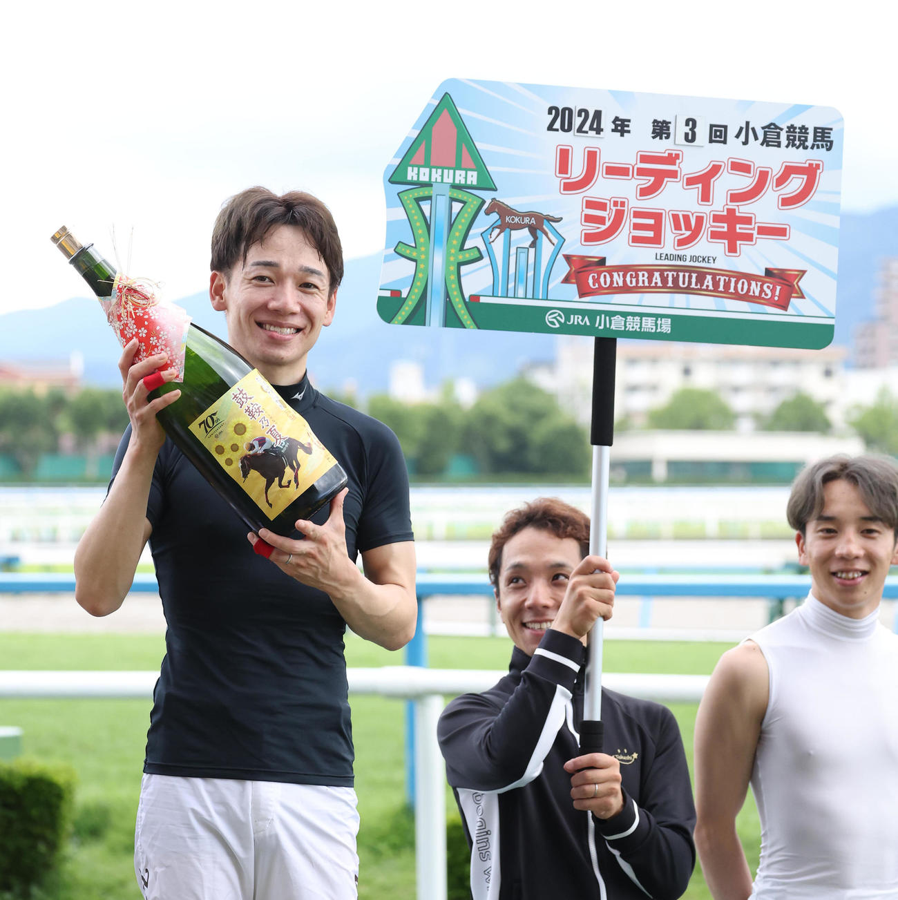 夏の小倉開催のリーディングジョッキーに輝きオリジナル焼酎を掲げる松山騎手（左）（撮影・白石智彦）
