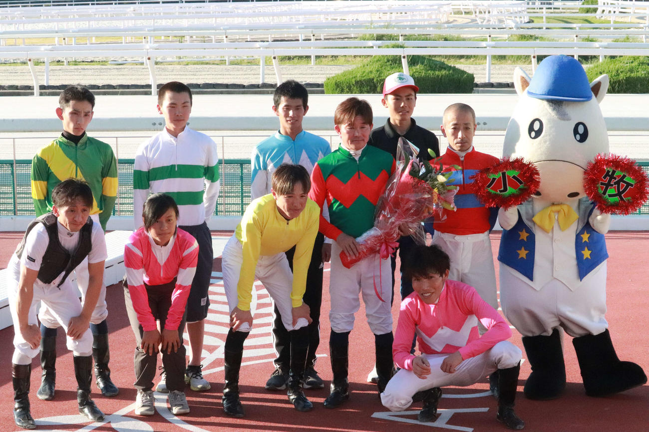 ファン紹介式で騎手に囲まれて復帰を祝された小牧太騎手（前列左から4人目）