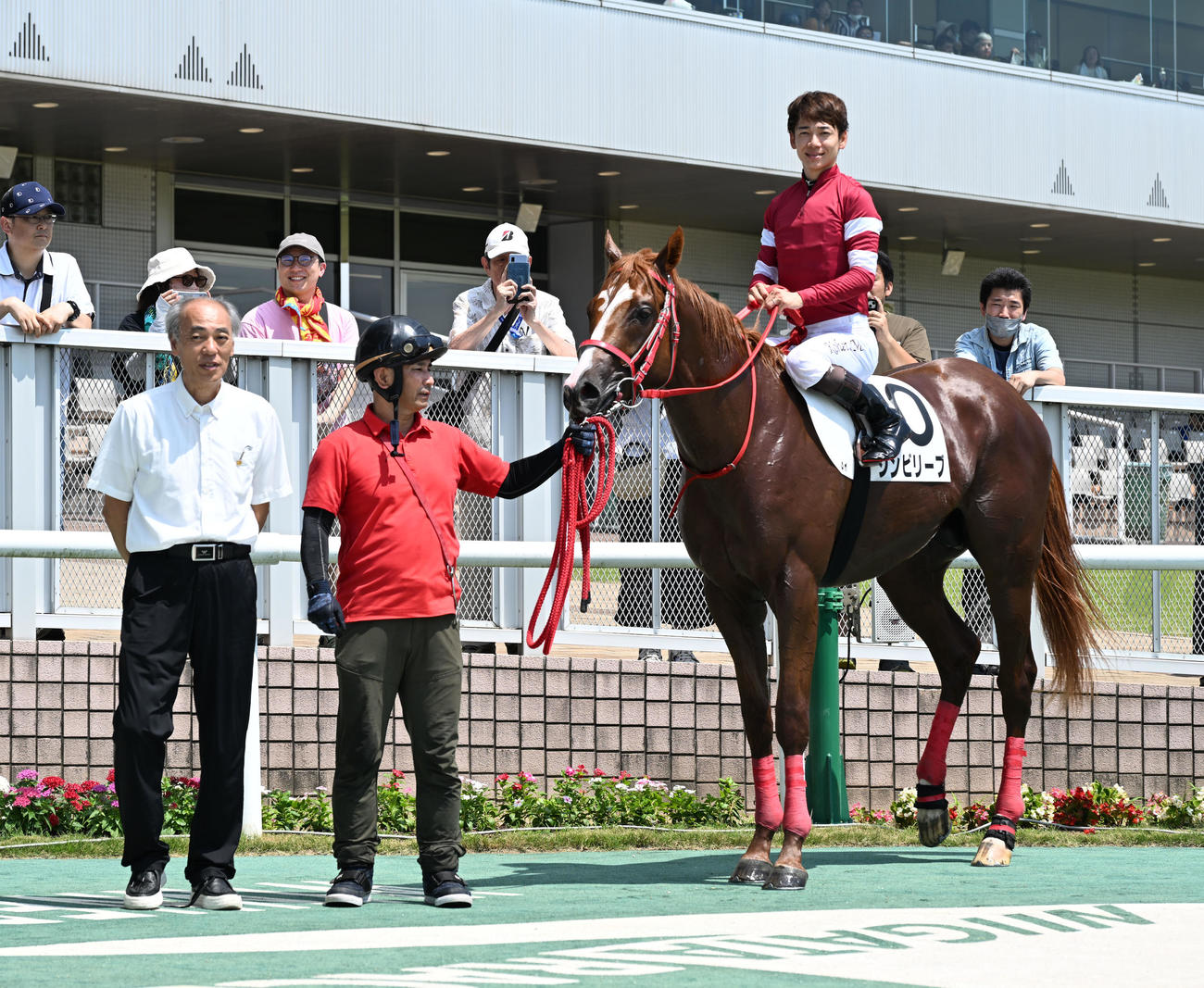 新潟3R　メイクデビュー新潟戦を制し、シンビリーブの口取りをする松山騎手と森師（撮影・千葉一成）