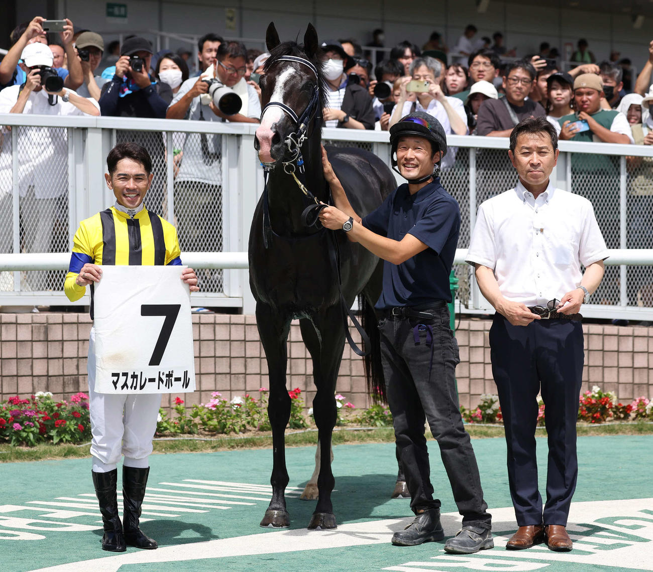 新潟5R新馬戦を制したマスカレードボールの口取りをする戸崎騎手と手塚貴久調教師（撮影・丹羽敏通）