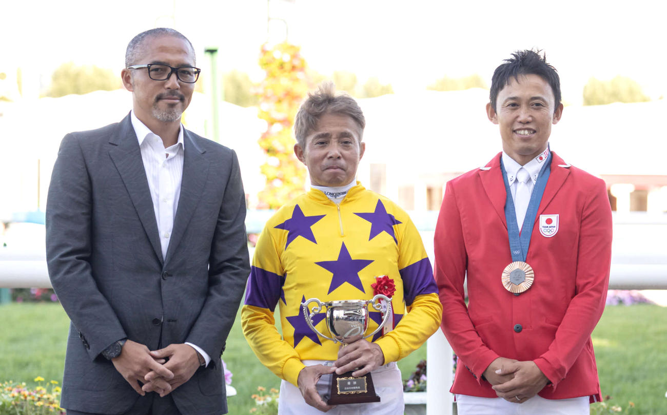 プレゼンターの小野伸二氏（左）、パリ五輪銅メダル戸本一真（右）と記念撮影する岩田康騎手