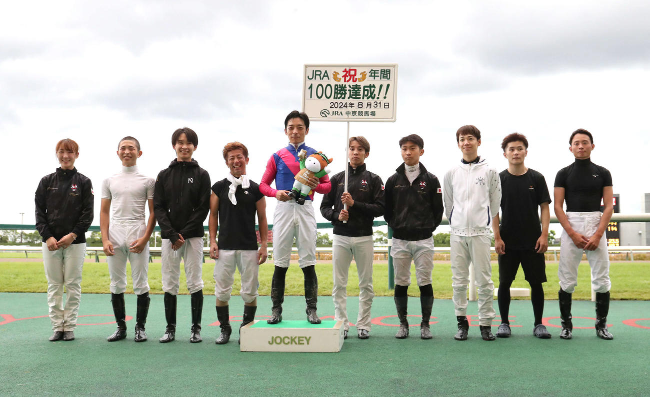 中京12RでJRA年間100勝を達成し騎手仲間と記念写真に納まる川田騎手（左から5人目）（撮影・白石智彦）
