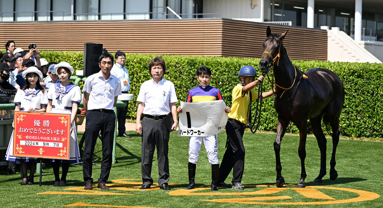 中山5R、2歳新馬戦を制したハードワーカーの口取りをする佐々木騎手と竹内師（左から3人目）