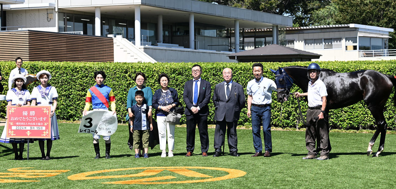 中山5R、牝馬限定の2歳新馬戦を制し、レイユールの口取りをする嶋田騎手と手塚師（右から2人目）