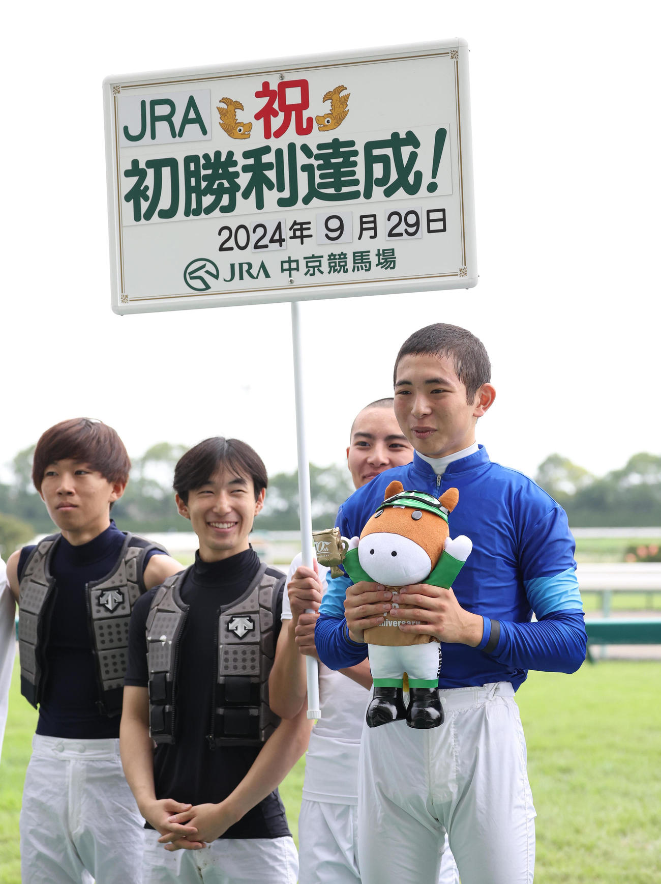 騎手仲間と記念写真に納まるJRA初勝利を挙げた橋木騎手（右）（撮影・白石智彦）