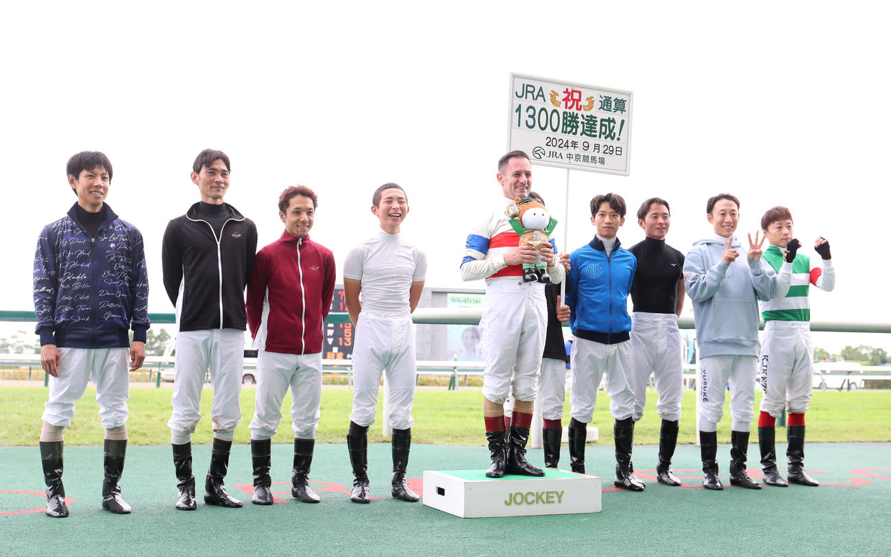 JRA通算1300勝を達成し騎手仲間と記念写真に納まるM・デムーロ騎手（中央）（撮影・白石智彦）
