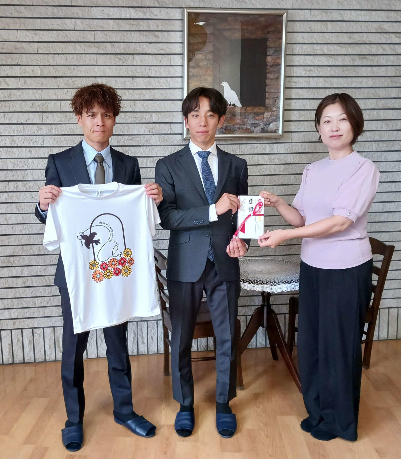 滋賀・大津市の児童養護施設「小鳩の家」を訪問し、チャリティーTシャツの売り上げによる寄付金を贈呈した高田騎手（左）と団野騎手。右は藤本邦子施設長（撮影・奥田隼人）