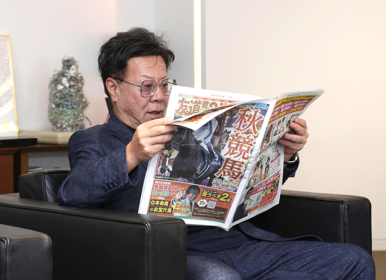 日刊スポーツ秋競馬特集号を見る松島オーナー（撮影・白石智彦）