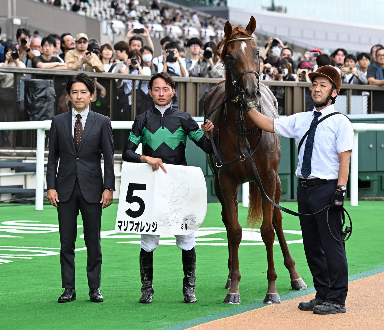 東京3R新馬戦を制したマリブオレンジの口取りをする岩田望騎手と福永師（撮影・千葉一成）
