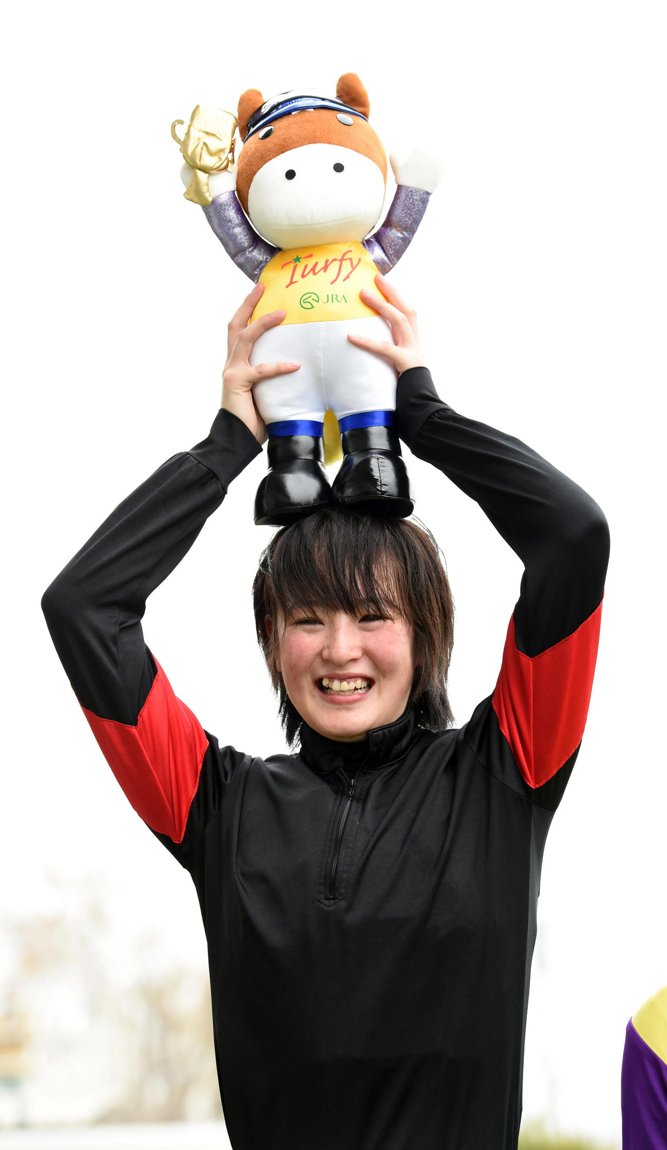 福島9R　サニーデイズでJRA初勝利を飾った藤田菜七子騎手は初勝利インタビューでマスコット人形を手に笑顔をみせる＝2016年4月10日　JRA初勝利