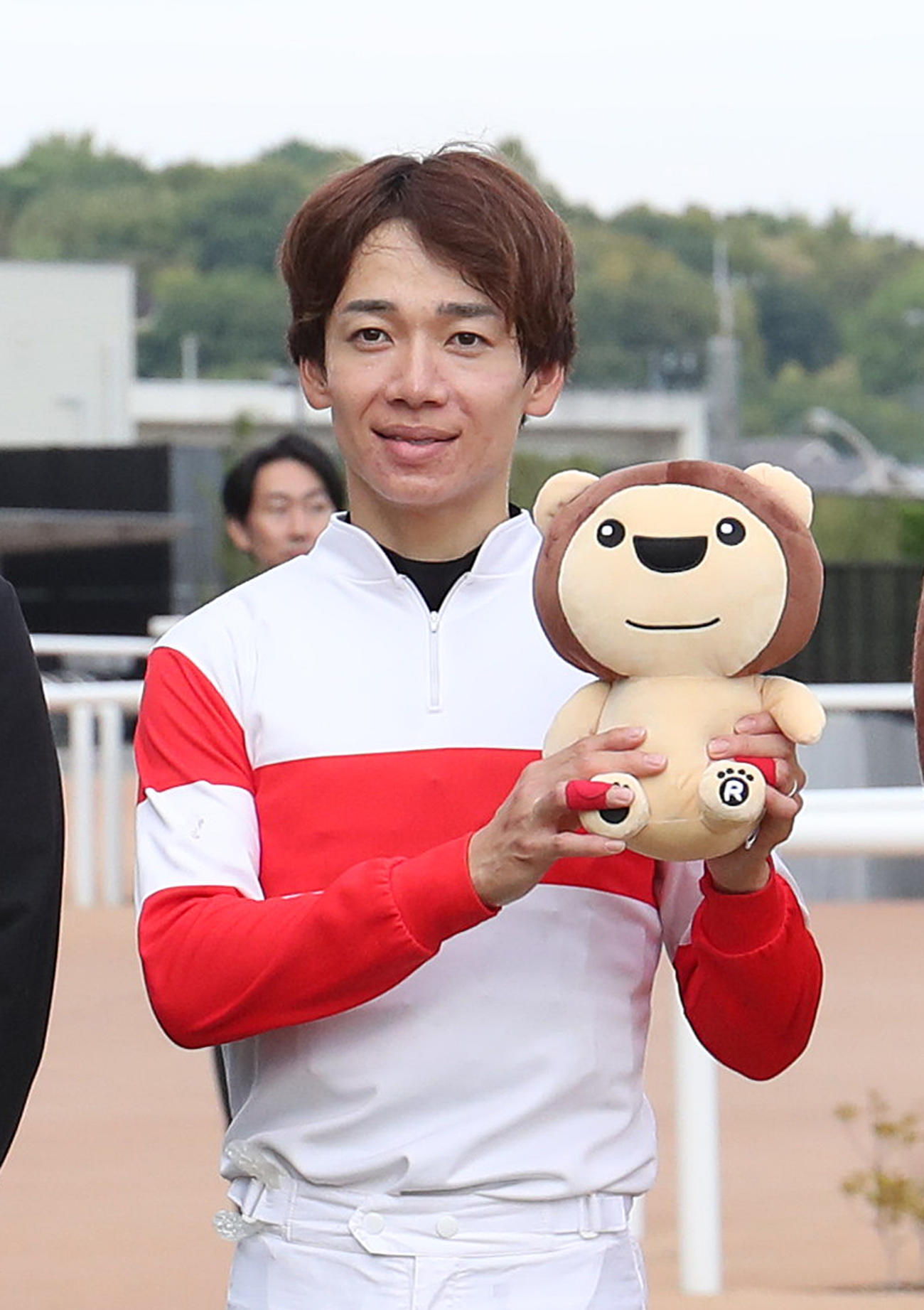 スワンSを制した松山騎手はらいよんチャンのぬいぐるみを掲げて記念写真に納まる（撮影・白石智彦）