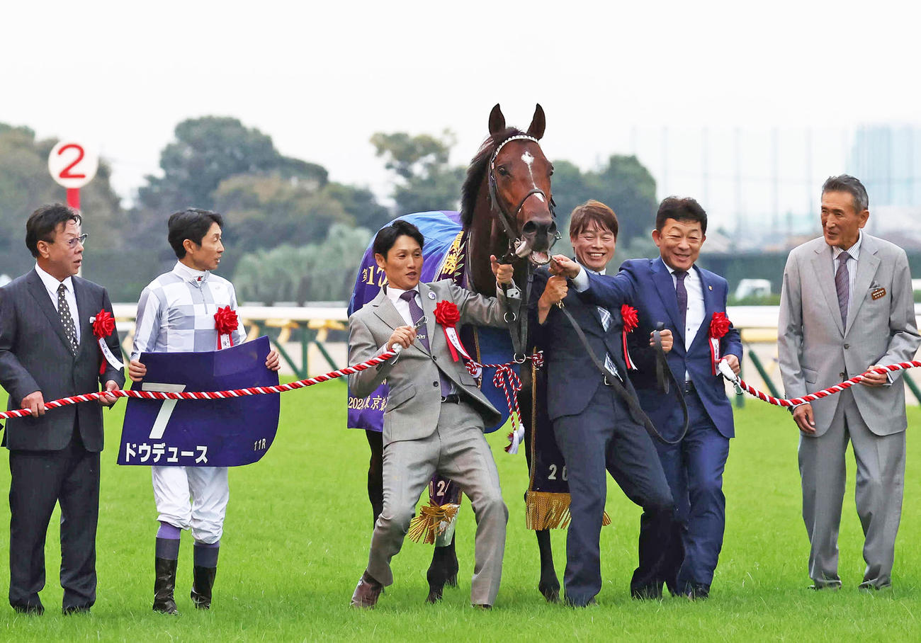 天皇賞・秋を制したドウデュースの口取りをする武豊騎手と友道師と関係者（撮影・丹羽敏通）