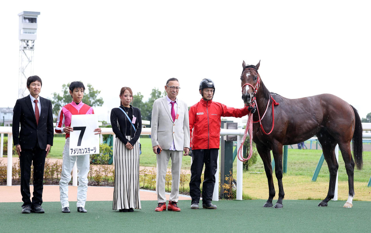 京都2R、レコードタイムで2歳未勝利を勝ち上がったアメリカンステージと口取りに並ぶ北村友騎手（左から2人目）（撮影・白石智彦）