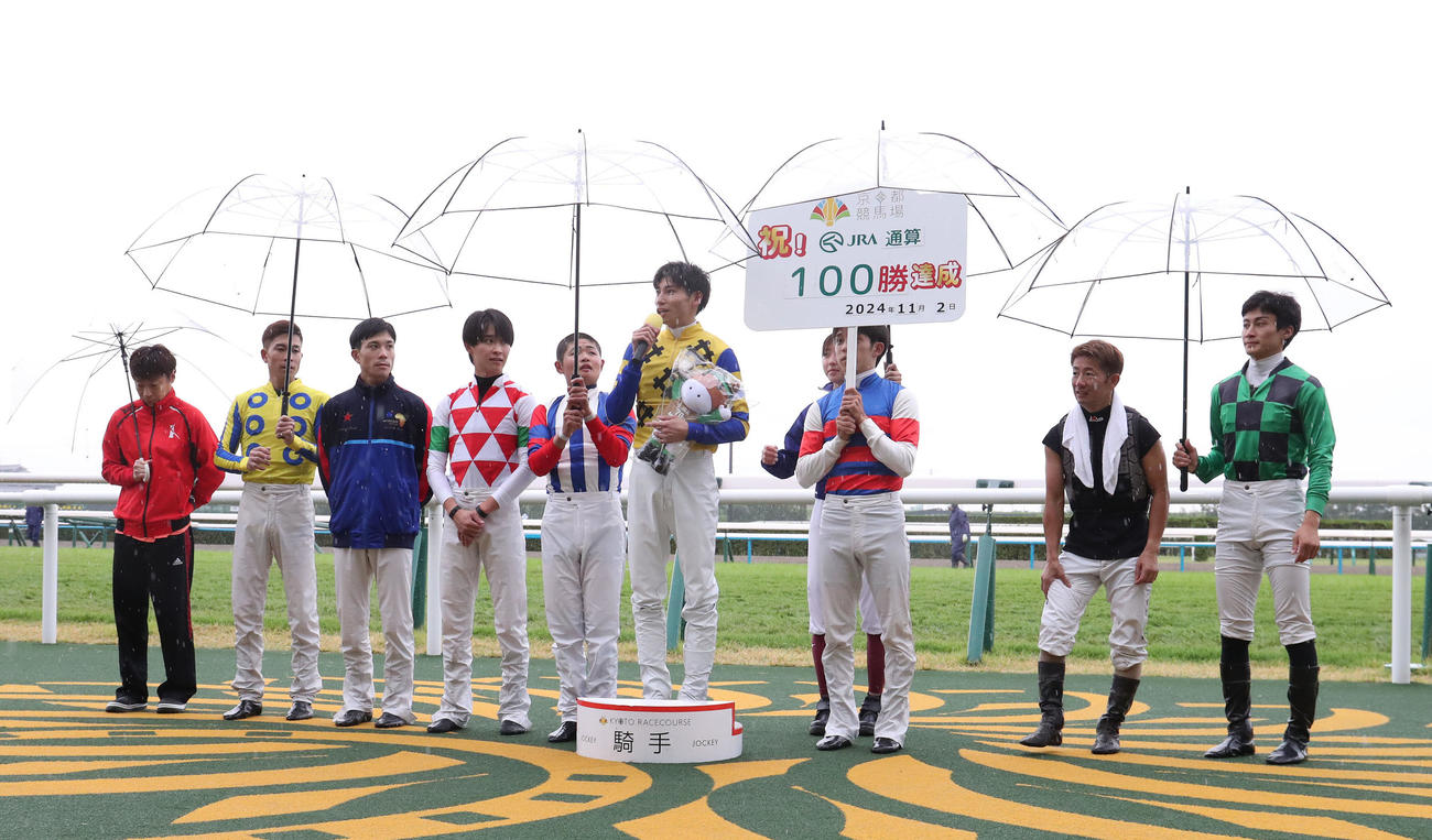 京都5RでJRA通算100勝を達成し、インタビューに答える長岡騎手（右から4人目）（撮影・白石智彦）