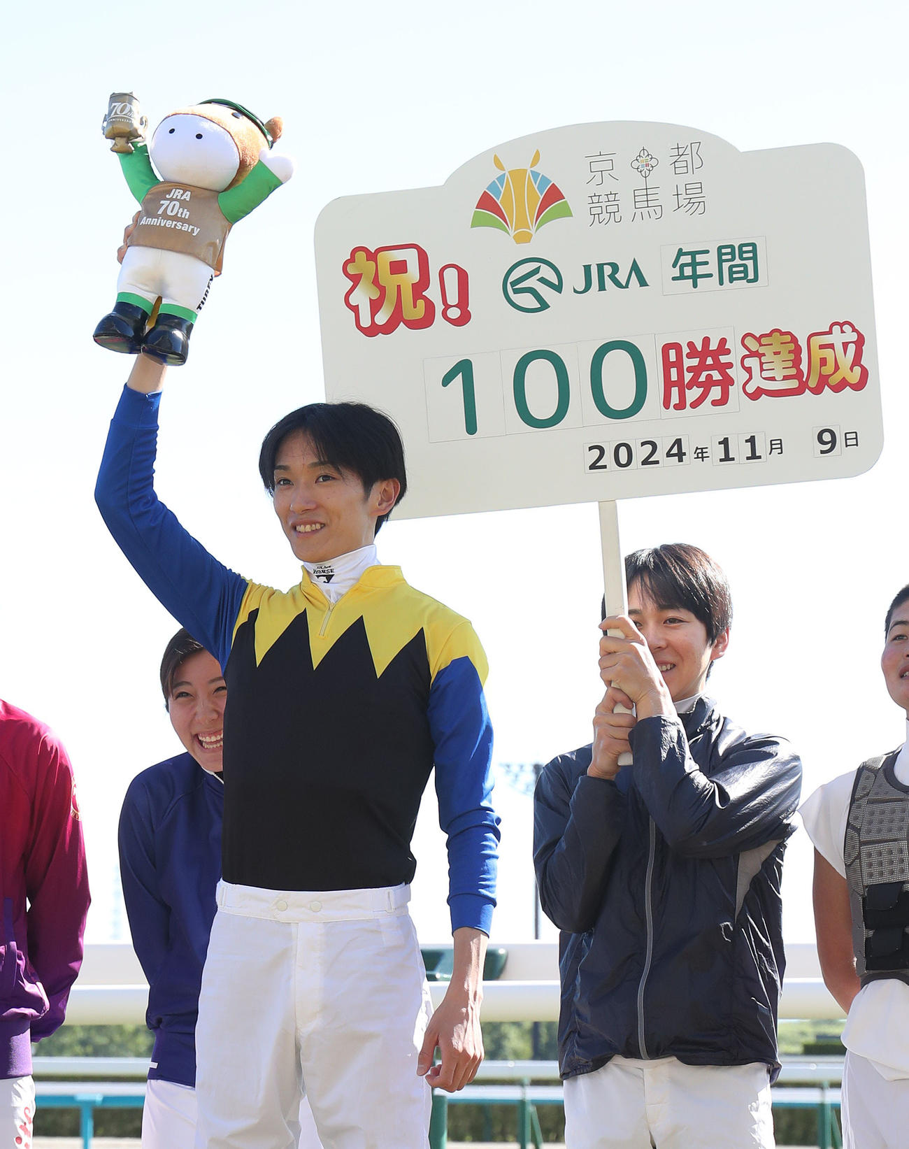 京都3R、年間100勝を達成して笑顔でターフィー人形を掲げる坂井騎手（撮影・白石智彦）