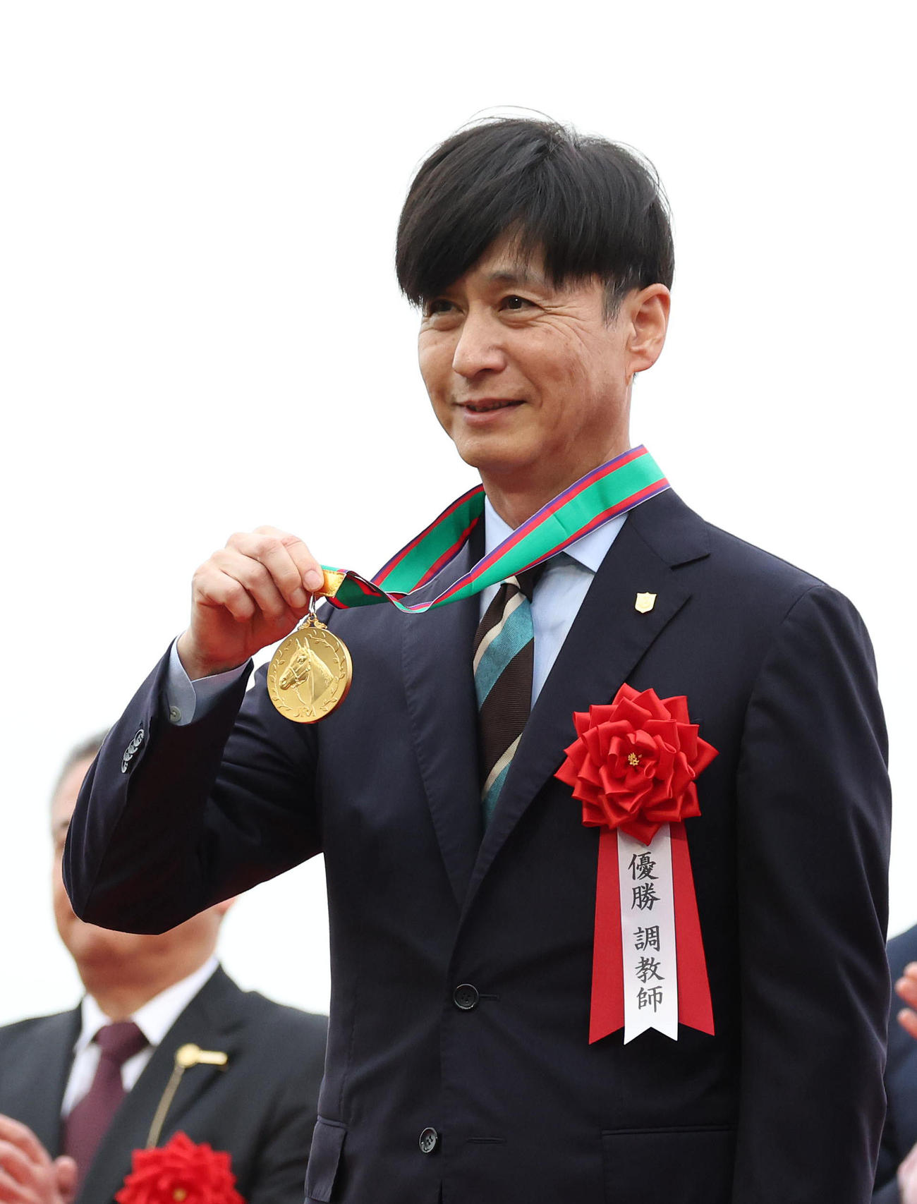 笑顔で優勝メダルを掲げる池江師（撮影・白石智彦）