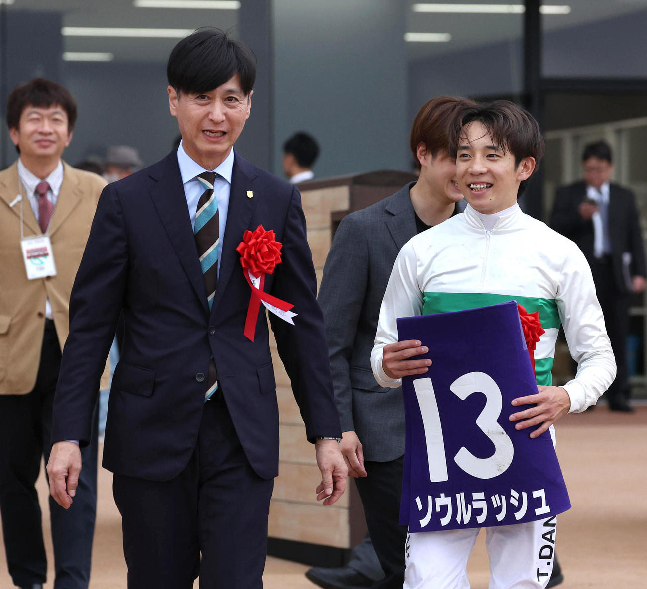 笑顔で口取りに向かう池江師（左）と団野騎手（撮影・白石智彦）