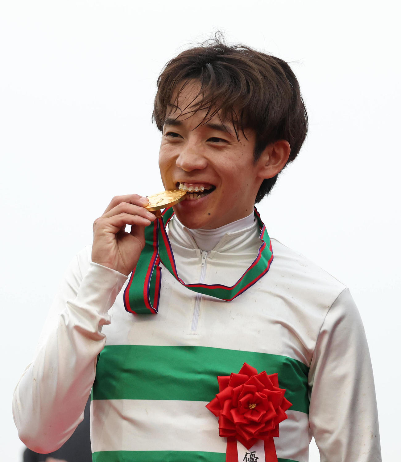 マイルCS、表彰式で優勝メダルをかじる団野騎手（撮影・白石智彦）