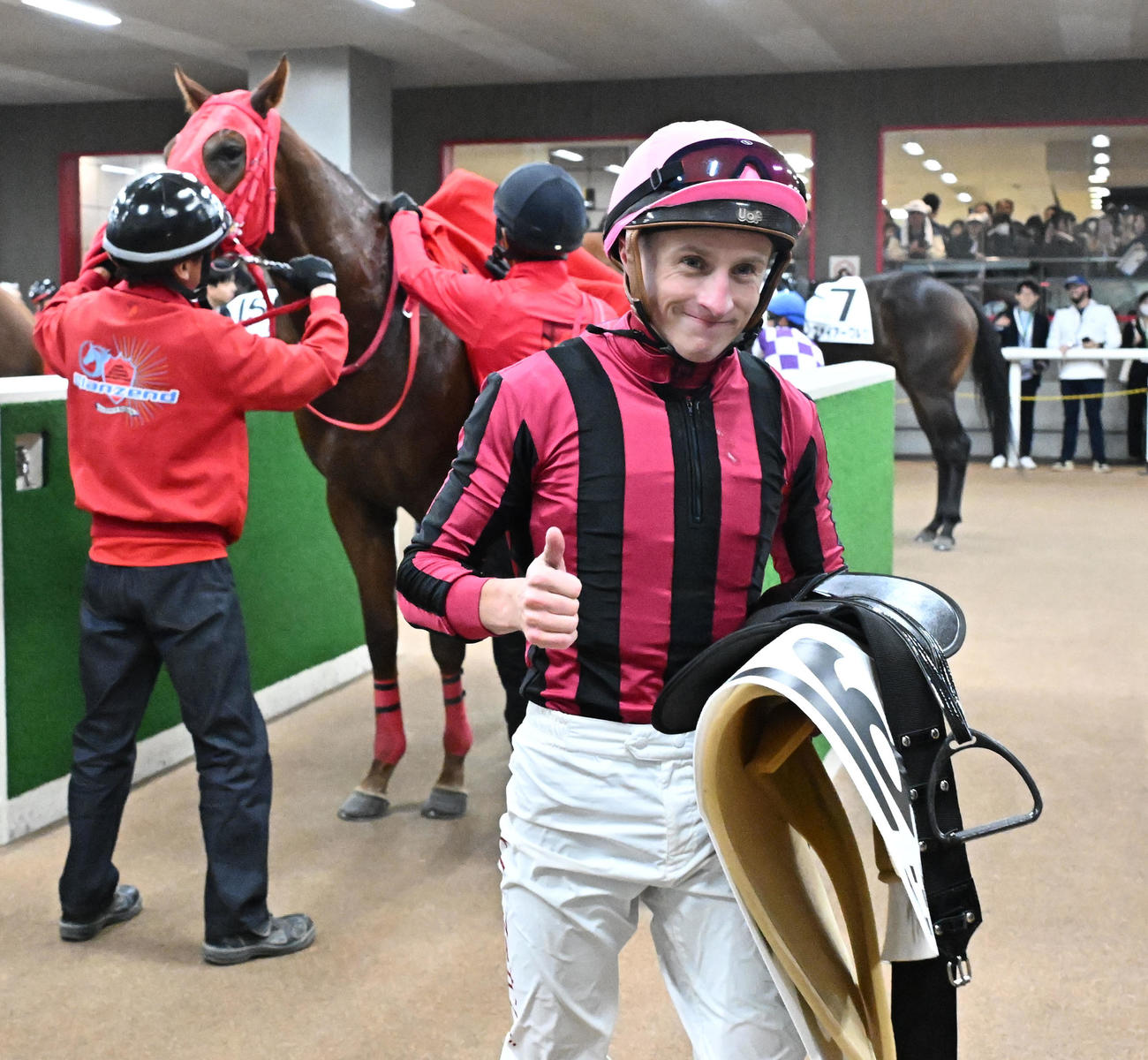2歳新馬戦をヘニーガイスト（左）で制し、サムアップポーズを見せるマーカンド騎手（撮影・千葉一成）