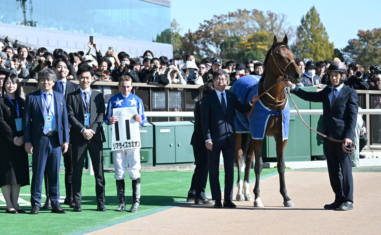 東京5R新馬戦を制したリアライズカミオンの口取りをするムーア騎手と堀師（右から2人目）ら関係者（撮影・千葉一成）