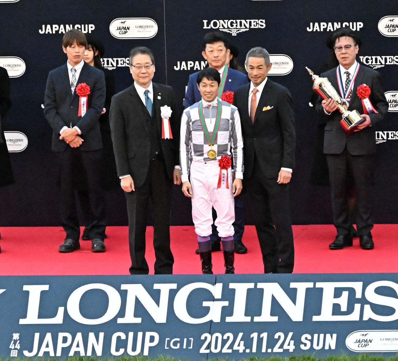 ジャパンCを制した武騎手（中央）ら関係者と記念撮影するプレゼンターを務めたイチローさん（同右）