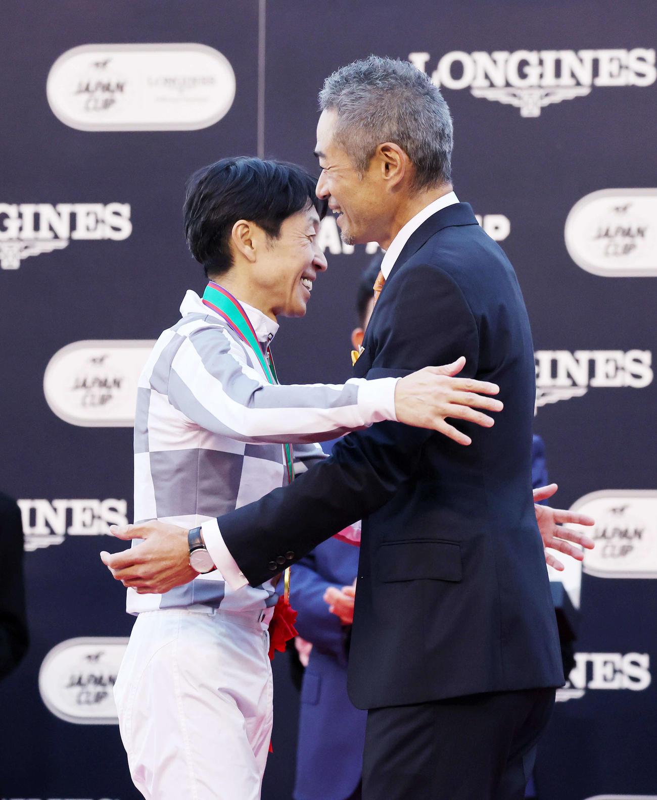 笑顔で抱き合う武豊騎手（左）とイチロー氏（撮影・鈴木正人）