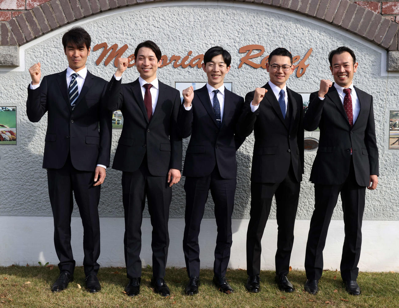 新規調教師試験に合格し笑顔でガッツポーズする、左から秋本助手、手塚助手、平岩助手、松尾助手、室井助手（撮影・柴田隆二）