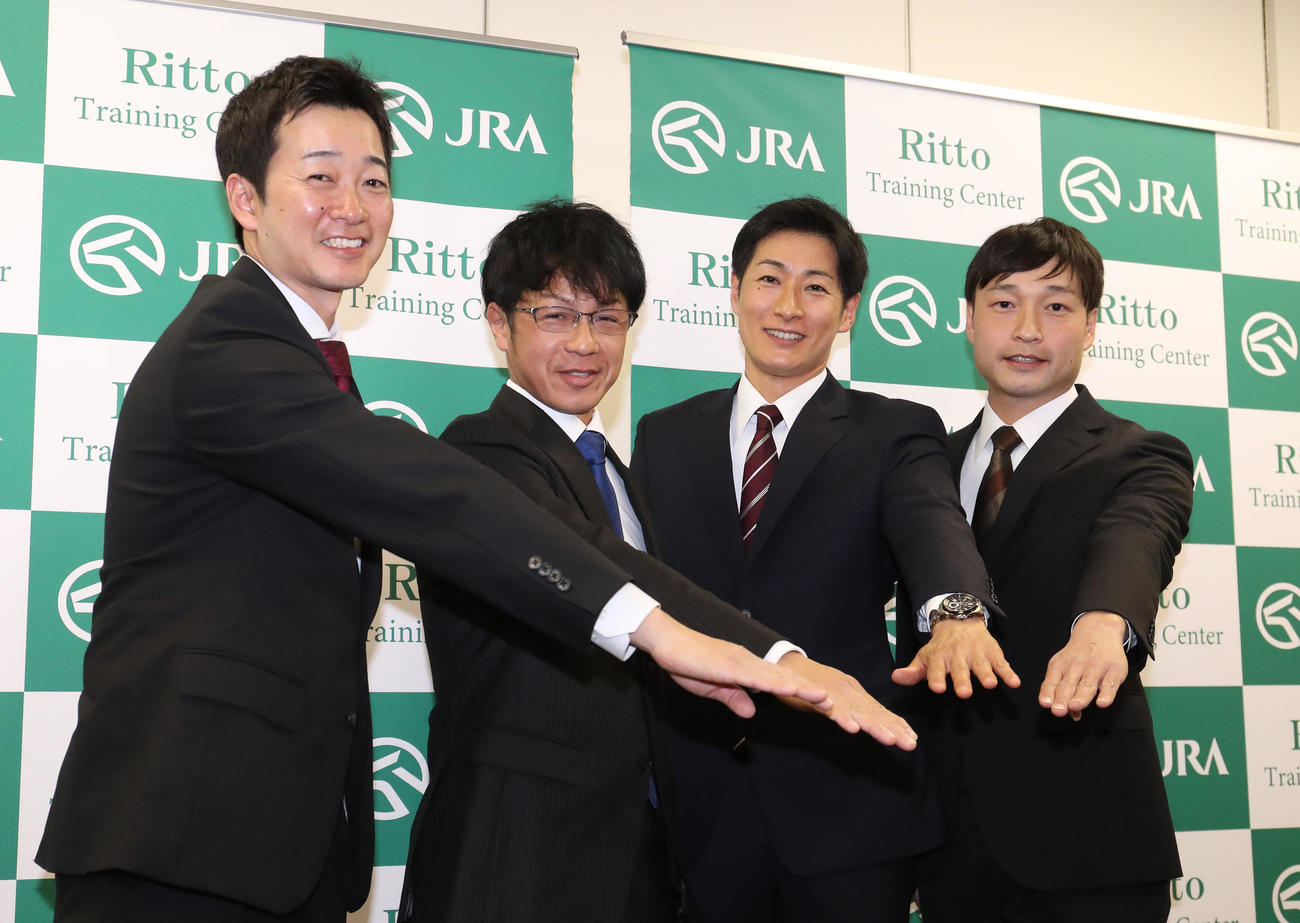 新規調教師免許に合格し笑顔で手を重ねる、左から井上助手、加藤助手、柴田助手、橋田助手