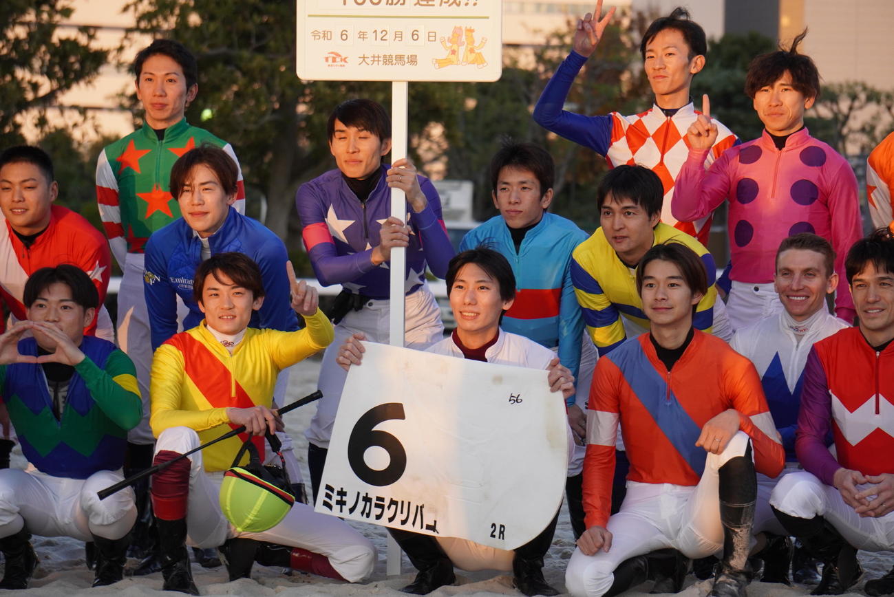 地方通算100勝を達成し、ゼッケンを掲げる江里口裕輝騎手（中央下段