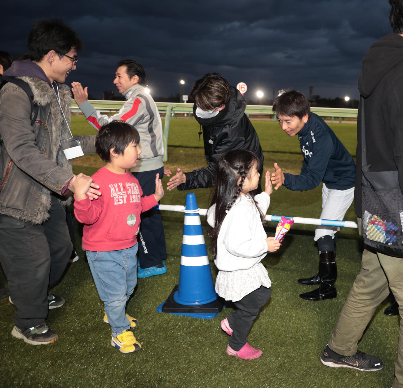 レース終了後、ファンとハイタッチする内田騎手ら騎手たち（撮影・柴田隆二）