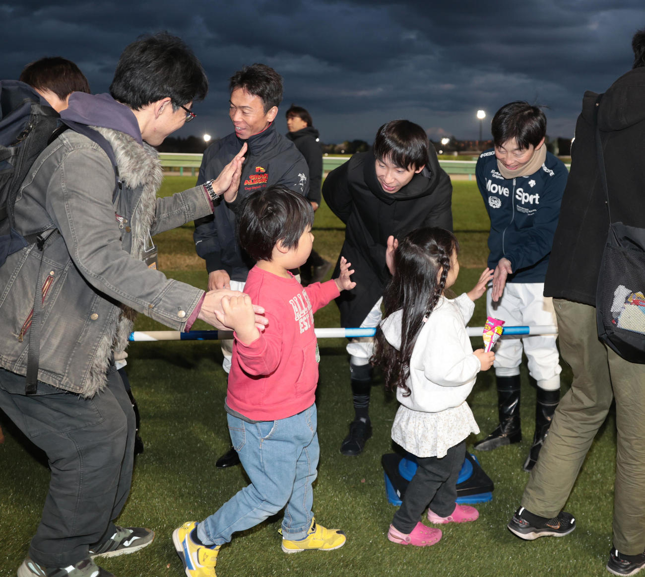 レース終了後、ファンとハイタッチする、左2人目から北村宏騎手、横山和騎手、丸田騎手（撮影・柴田隆二）