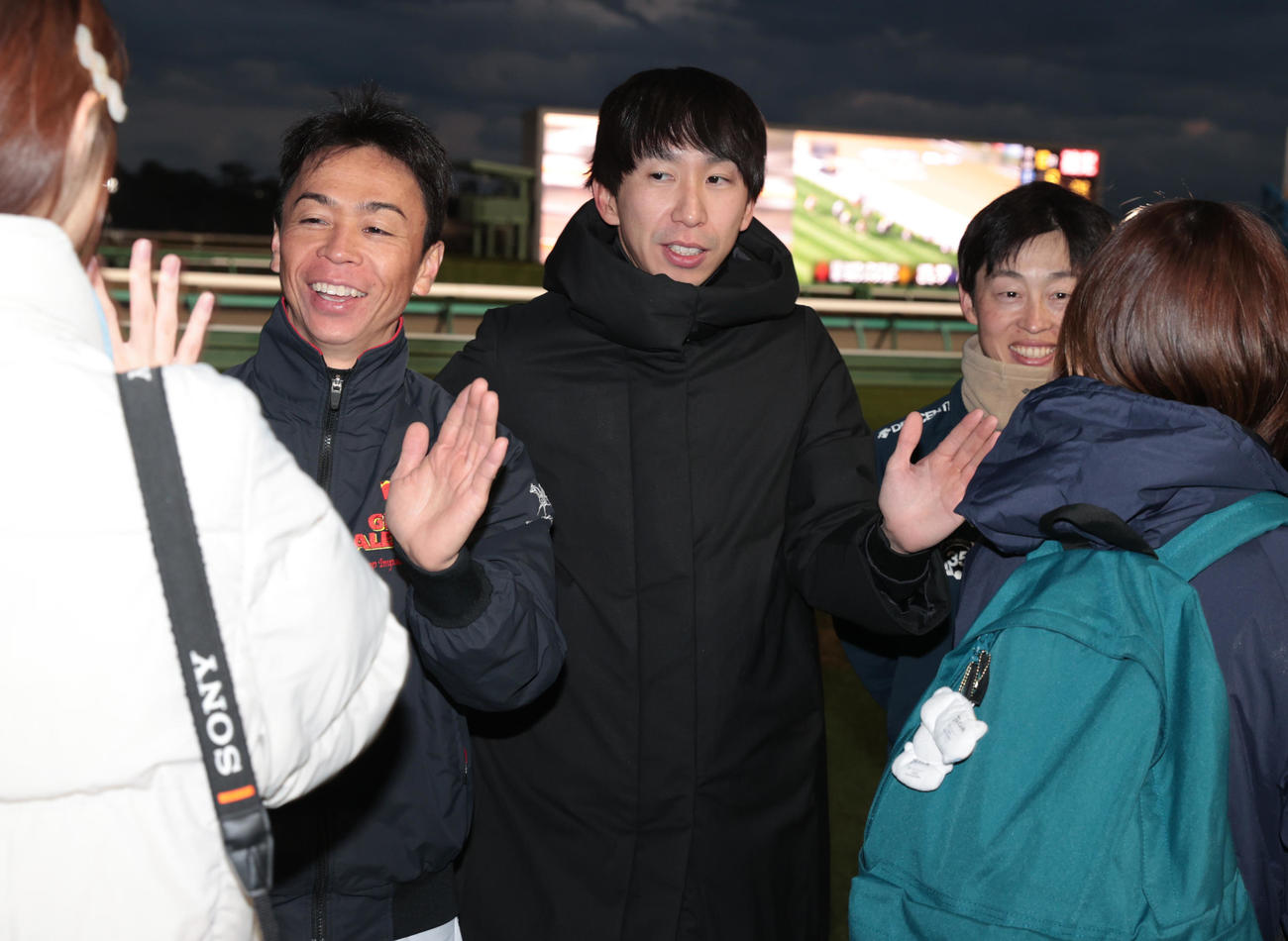 レース終了後、ファンとハイタッチする、左から北村宏騎手、横山和騎手、丸田騎手（撮影・柴田隆二）