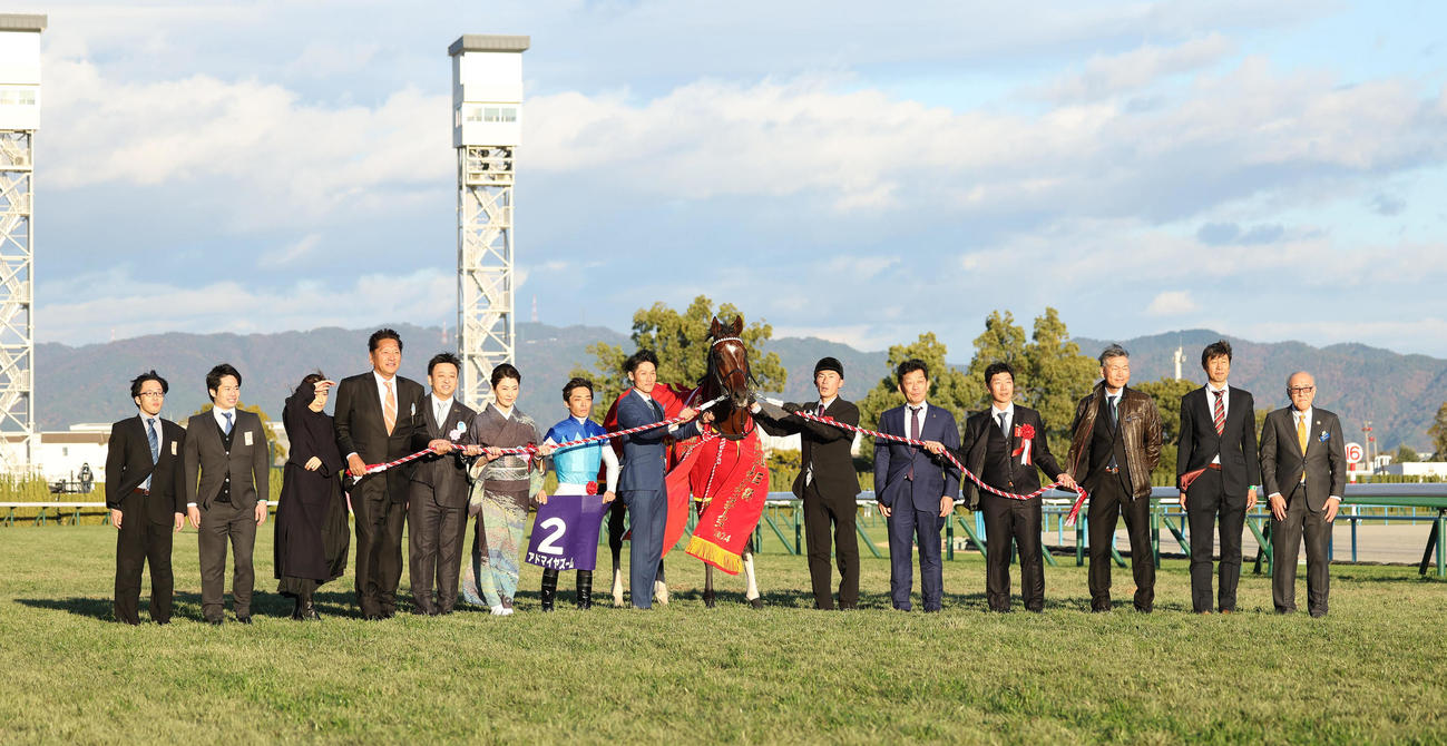 朝日杯FSを制したアドマイヤズームと口取りに並ぶ川田騎手（中央）（撮影・白石智彦）