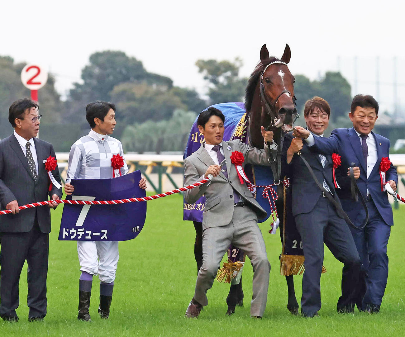 天皇賞・秋の口取りで友道師（右）らを引っ張ろうとするドウデュース